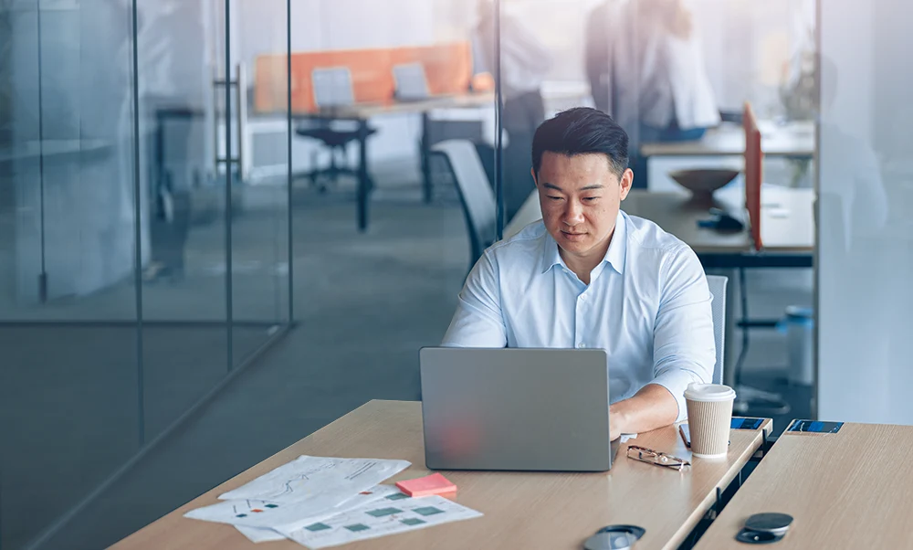 Man typing on laptop in workplace